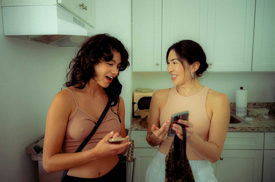 Two friends laughing while recording a podcast episode together
